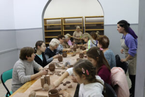 Seniorzy i dzieci podczas warsztatów ceramicznych